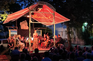 Die Roseninsel ist eine rollende Bühne mit eigener Technik, inspiriert von Giorgio Rosas Mikronation. Ein verzaubernder, mobiler Veranstaltungsort mit Bar, Tanzfläche und ausfahrbarem Dach – flexibel einsetzbar und voll ausgestattet.